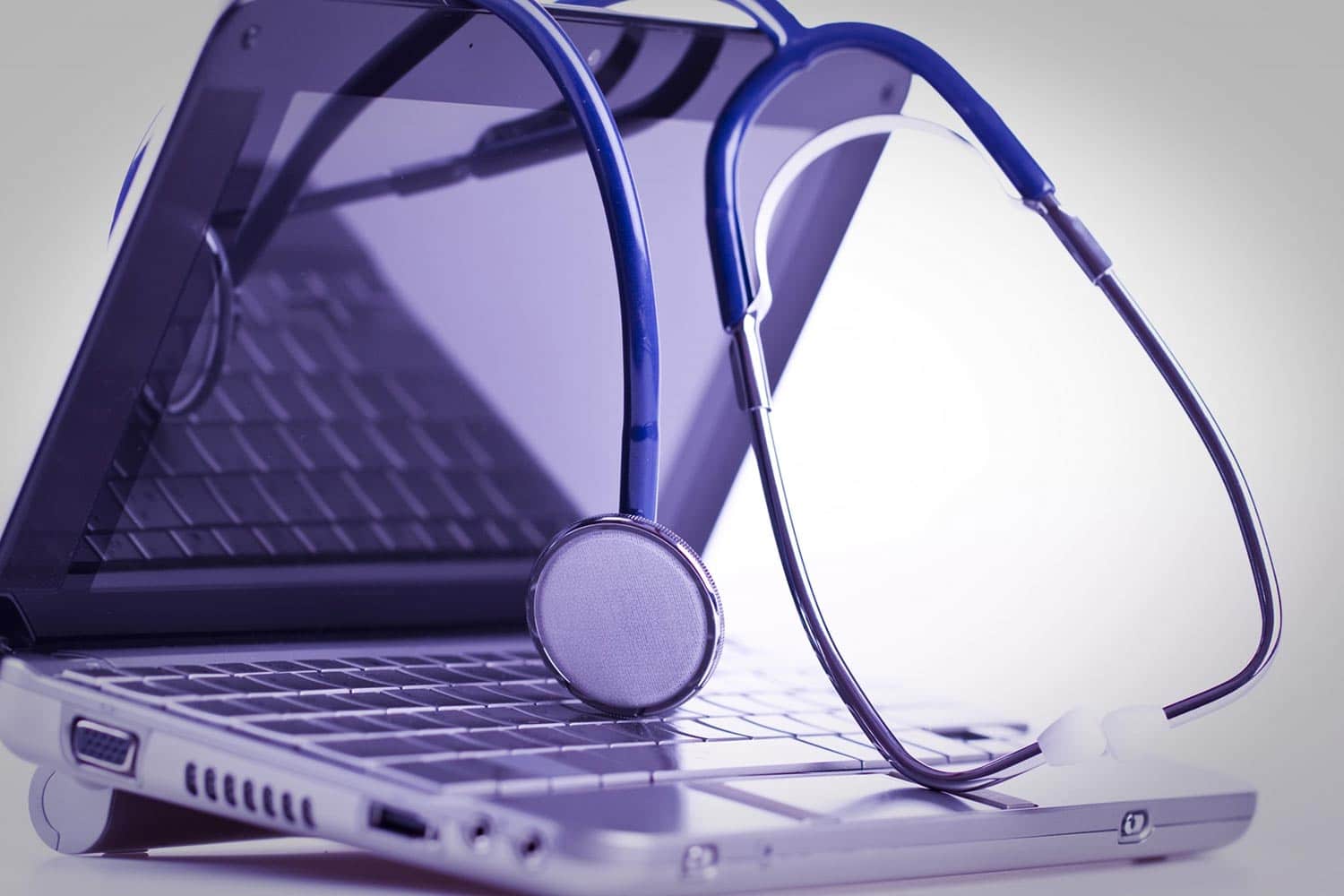 Close up of a stethoscope draped over a laptop